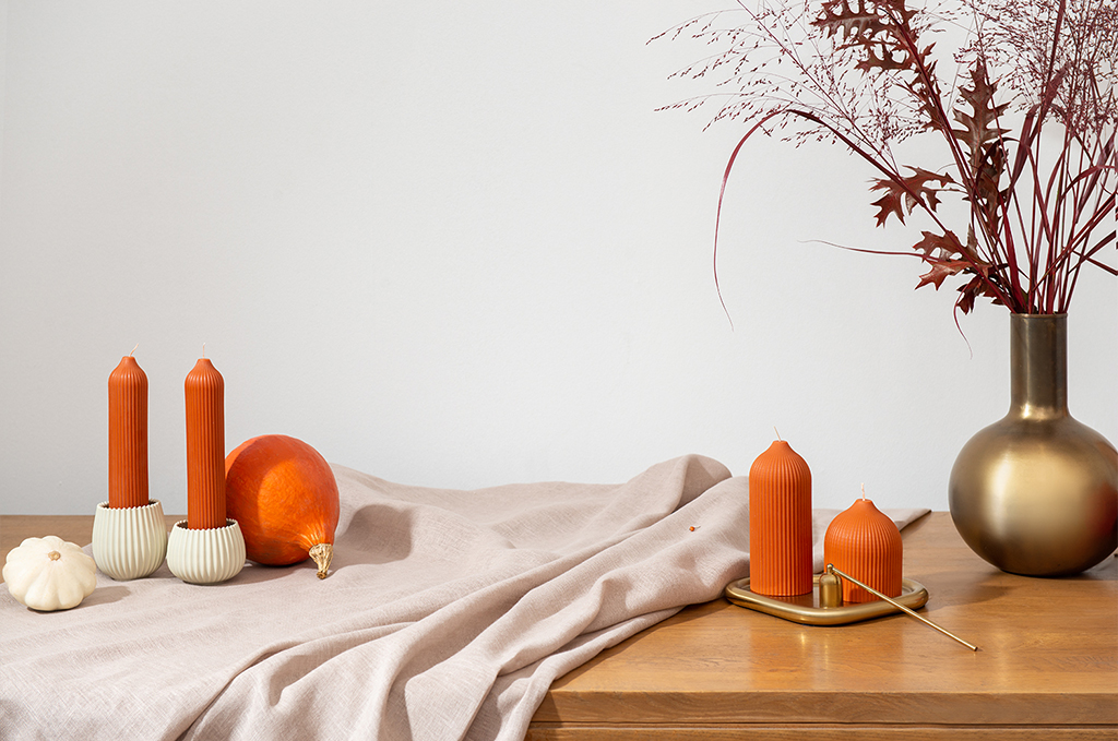 На фото: тыквы и оранжевые декоративные свечи Tkano
